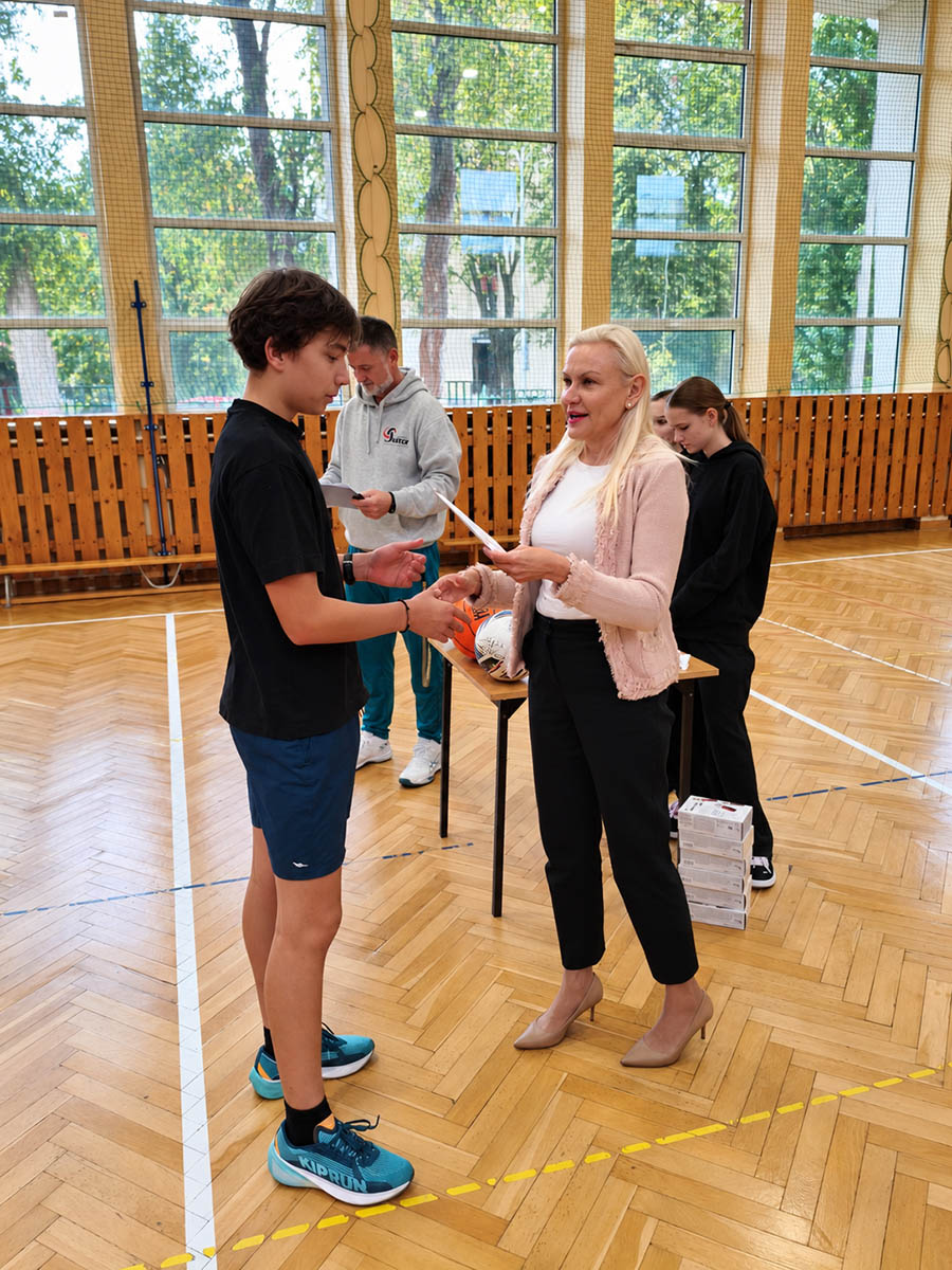 Pani dyrektor Alicja Wodecka wręcza upominek uczniowi biorącemu udział w Dniu Sportu Szkolnego