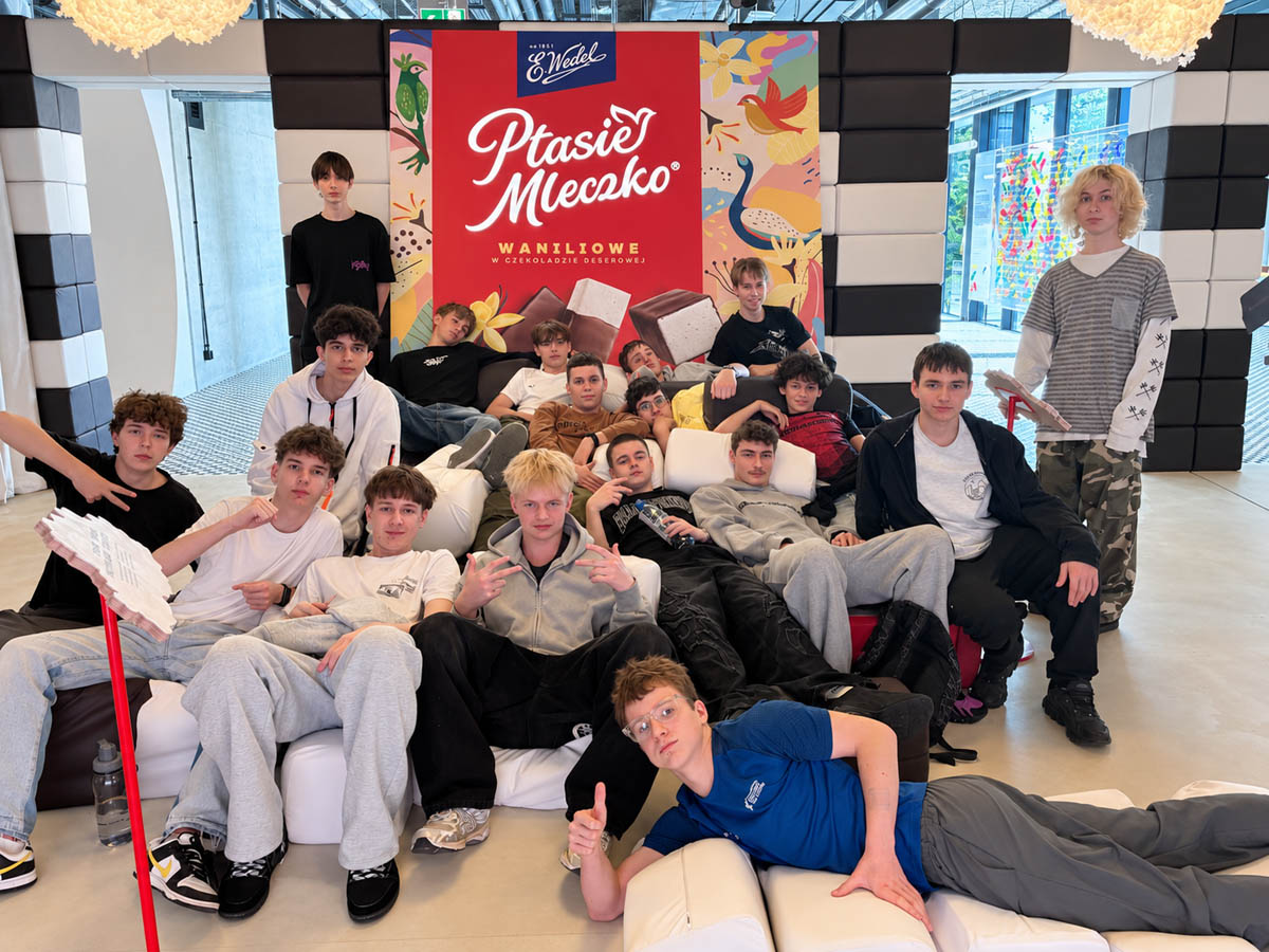 Grupa uczniów pozuje do wspólnego zdjęcia podczas wizyty w muzeum czekolady Wedla