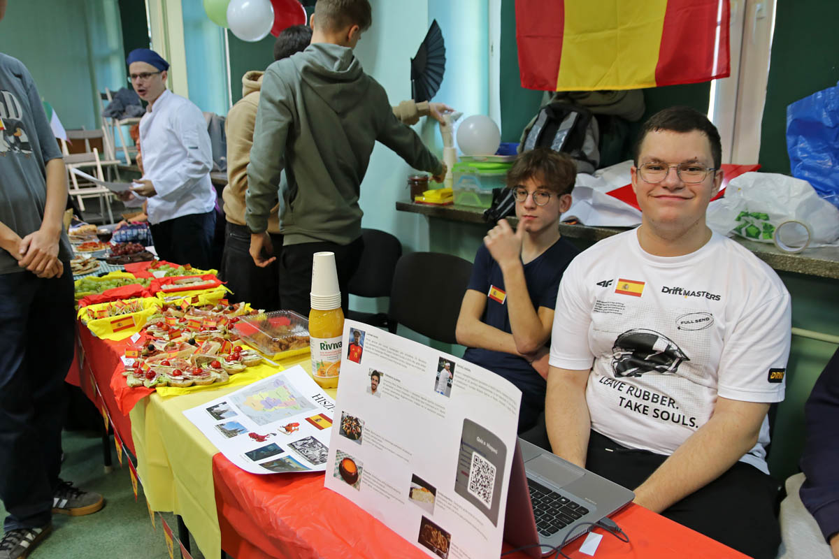 Uczniowie przy stoisku udekorowanym barwami Hiszpanii i materiałami o kraju.