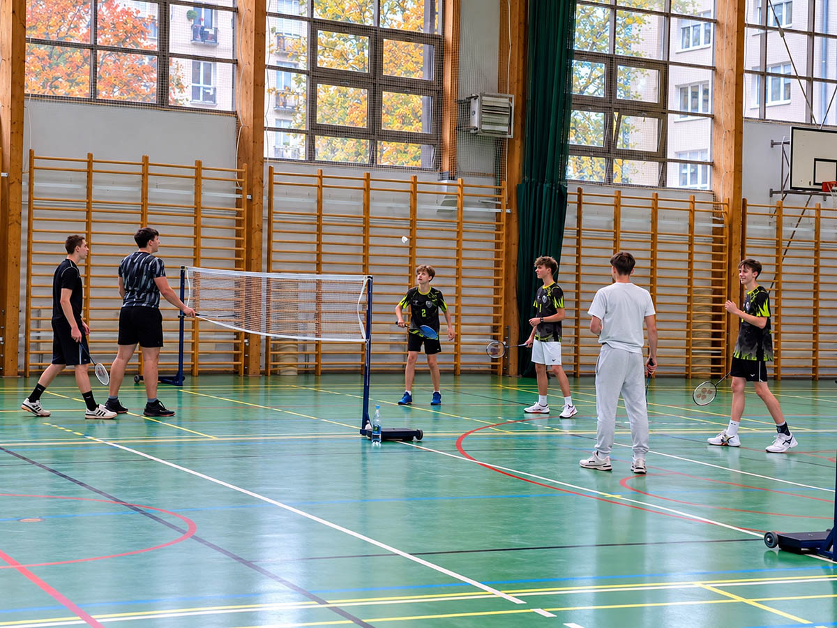 Uczniowie rozgrywają mecz badmintona podczas mistrzostw dzielnicy Praga-Południe szkół średnich