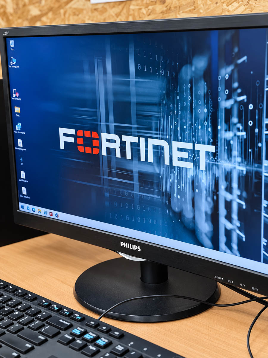 Monitor stanowiska komputerowego z wyświetlonym logo Fortinet