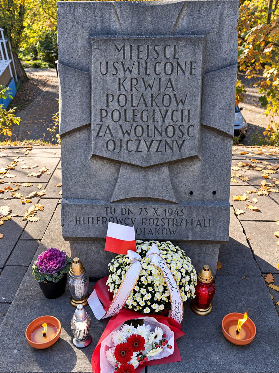 Miejsce pamięci Polaków poległych za wolność ojczyzny z kwiatami, zniczami i biało-czerwoną wiązanką