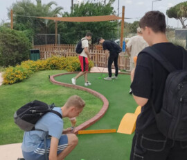 Uczestnicy mobilności stoją przy wejściu na teren minigolfa.