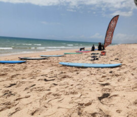 Uczeń ćwiczy surfing na plaży nad Atlantykiem.
