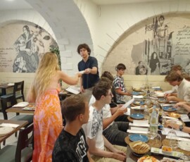 Grupa uczestników Erasmus+ stoi przy stole podczas ostatniego spotkania kończącego mobilność.