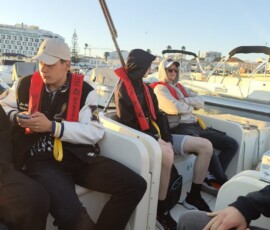 Łódź motorowa płynie obok grupy Erasmus+ podczas rejsu po wodach Faro.