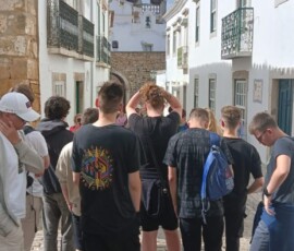 Grupa Erasmus+ spaceruje wąską ulicą w mieście.