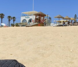 Plaża w Faro z wieżą ratowniczą i plecakami uczestników mobilności Erasmus+.