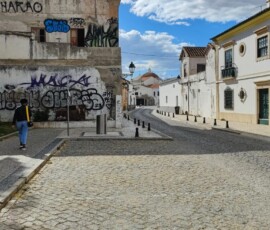 Plac w Faro z budynkiem pokrytym graffiti oglądany podczas spaceru Erasmus+.