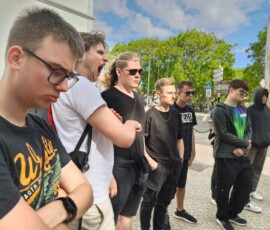 Uczniowie słuchają przewodnika podczas spaceru po Faro.