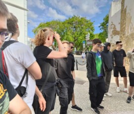 Uczniowie stoją w grupie i słuchają objaśnień podczas zwiedzania Faro.