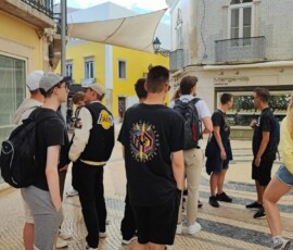 Uczniowie stoją przy ceramicznej mapie Faro podczas spaceru po mieście.