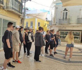 Grupa uczniów zatrzymuje się przy pomniku w Faro.