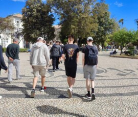 Uczestnicy Erasmus+ stoją razem na ulicy podczas zwiedzania historycznego centrum Faro.