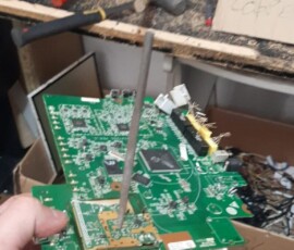 Uczeń trzyma płytkę elektroniczną i narzędzia podczas praktyk zawodowych w Portugalii.