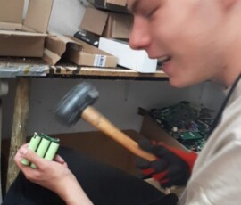 Uczeń pracuje ręcznie z niewielkim podzespołem elektronicznym podczas praktyk Erasmus+.