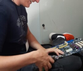 Uczeń naprawia urządzenie przy stanowisku roboczym podczas praktyk Erasmus+ w Portugalii.