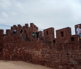 Uczniowie idą ścieżką prowadzącą nad skalistym wybrzeżem w Lagos.