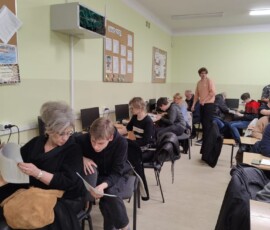 Uczniowie i rodzice siedzą w sali podczas spotkania informacyjnego przed mobilnością Erasmus+ do Faro.