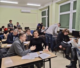 Uczestnicy mobilności i rodzice słuchają informacji organizacyjnych podczas spotkania przed wyjazdem do Faro.