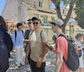 Uczestnicy Erasmus+ stoją przy zabytkowej zabudowie w Lizbonie.