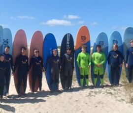 Kolorowe deski surfingowe ustawione na plaży przed lekcją surfingu nad Atlantykiem.