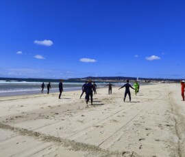Uczniowie rozpoczynają lekcję surfingu na plaży w Figueira da Foz.