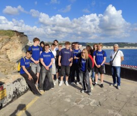 Grupa uczestników Erasmus+ na klifie z widokiem na Atlantyk w Nazaré.