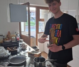 Uczeń przygotowuje potrawę przy kuchence podczas czasu wolnego po praktykach.
