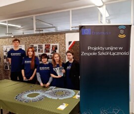 Uczniowie stoją przy banerze i materiałach promujących mobilność Erasmus+ do Figueira da Foz.