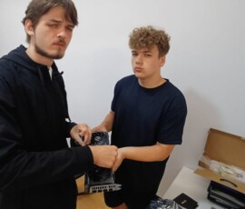Uczniowie rozmawiają przy stanowisku komputerowym podczas praktyk w Portugalii.