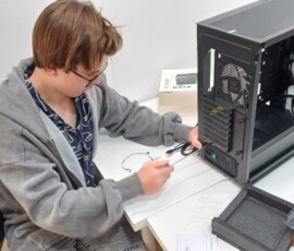 Uczeń dokumentuje pracę przy komputerze stacjonarnym podczas praktyk Erasmus+.