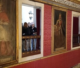 Drewniana galeria z obrazami i dekoracjami we wnętrzu zabytkowego kompleksu.