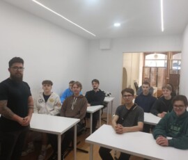 Grupa uczniów i prowadzący znajdują się w sali podczas spotkania w szkole partnerskiej.