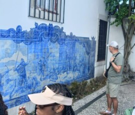 Uczestniczka ogląda dekoracyjne portugalskie azulejos podczas zwiedzania Lizbony.
