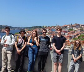 Grupa uczestników pozuje na punkcie widokowym z panoramą Porto w tle.