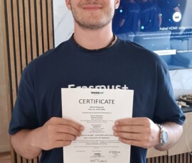 Uczeń prezentuje certyfikat ukończenia praktyk w Portugalii.