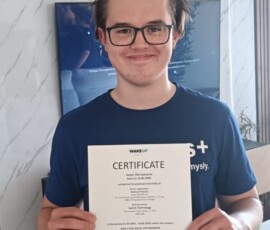 Uczeń prezentuje certyfikat otrzymany w ramach projektu Erasmus+.