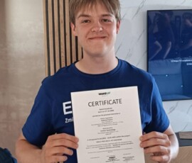 Uczeń trzyma dokument potwierdzający udział w mobilności zawodowej.
