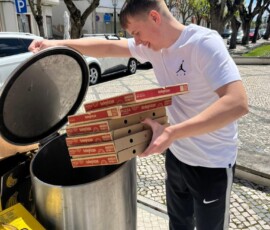 Uczeń opróżnia zebrane odpady do dużego pojemnika podczas pobytu Erasmus+.