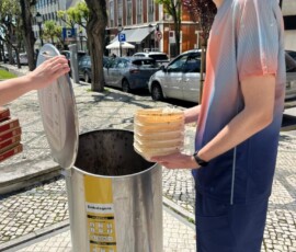 Uczeń wrzuca odpady do ulicznego pojemnika podczas codziennej segregacji śmieci w Portugalii.