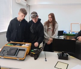 Grupa uczniów wspólnie pracuje przy urządzeniach podczas praktyk w Portugalii.