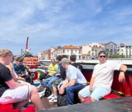 Uczniowie siedzą w łodzi podczas rejsu po rzece Douro w Porto.