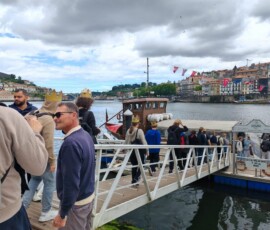 Grupa uczniów kończy zwiedzanie Porto na nabrzeżu.