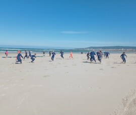 Uczniowie przygotowują się do lekcji surfingu na plaży nad Atlantykiem.