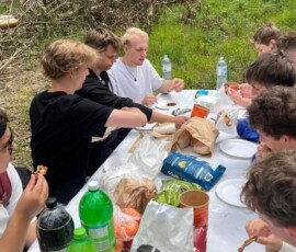 Uczniowie siedzą przy stole podczas pikniku w Serra da Boa Viagem.