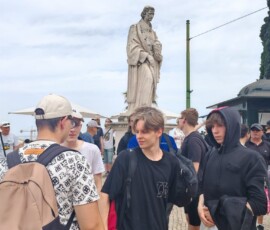 Uczniowie i opiekunowie pozują przy pomniku podczas zwiedzania Lizbony.