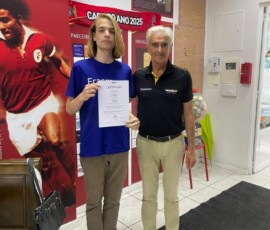 Uczeń pozuje z certyfikatem i opiekunem podczas zakończenia mobilności.