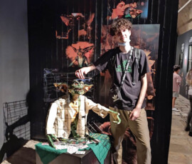 Uczeń pozuje przy figurach z filmu „Gremlins 2” podczas zwiedzania wystawy filmowej w Alicante.