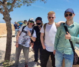 Grupa uczniów odpoczywa w cieniu drzewa podczas wycieczki do Alicante.